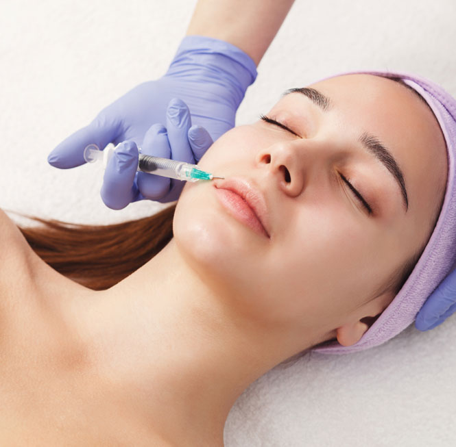 Woman receiving a dermal filler injection along her top lip.