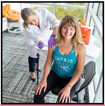 Kelly administering a vitamin b-12 injection to a happy, healthy patient.